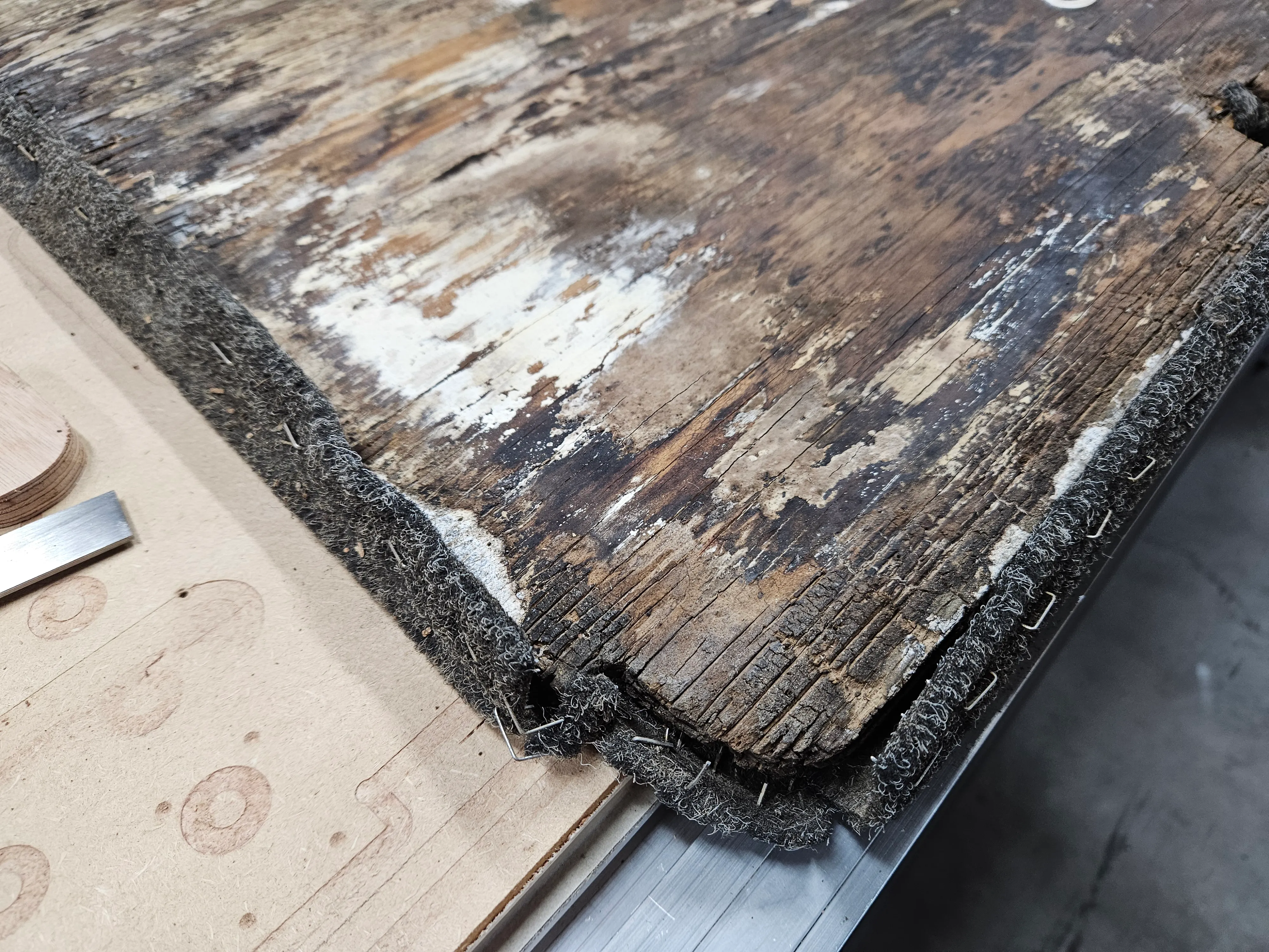 Close-up of water damage and delamination on the original panel