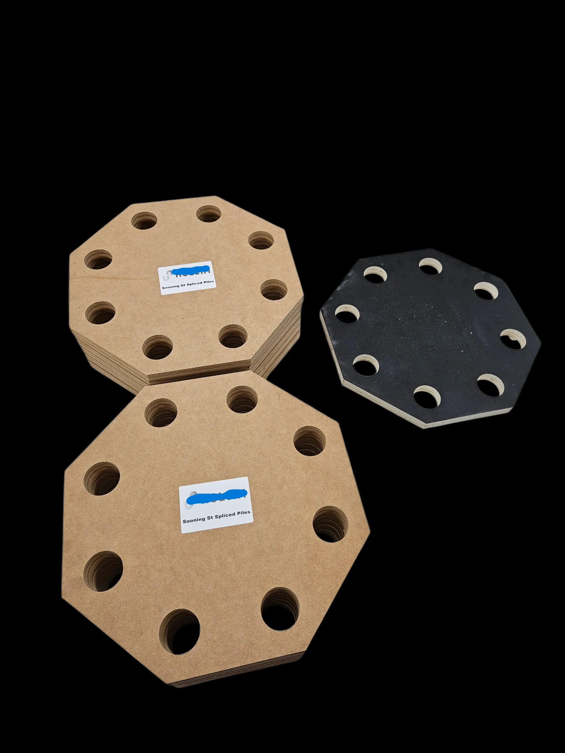 Stack of octagonal 9mm MDF bolt templates with an eight-hole flange pattern, alongside the customer's reference template in black
